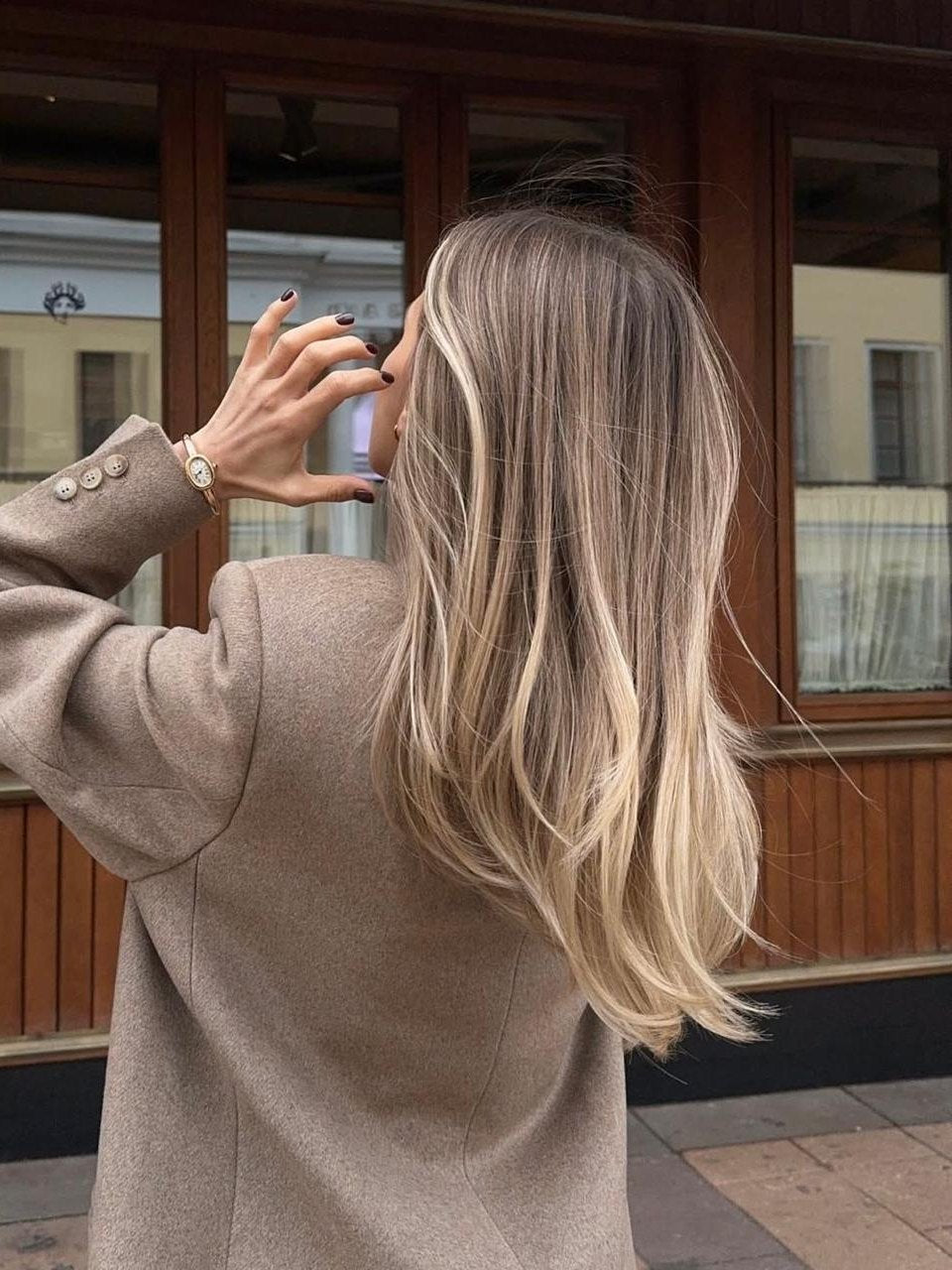 Glattes Beigeblond von hinten, vor einem Schaufenster
