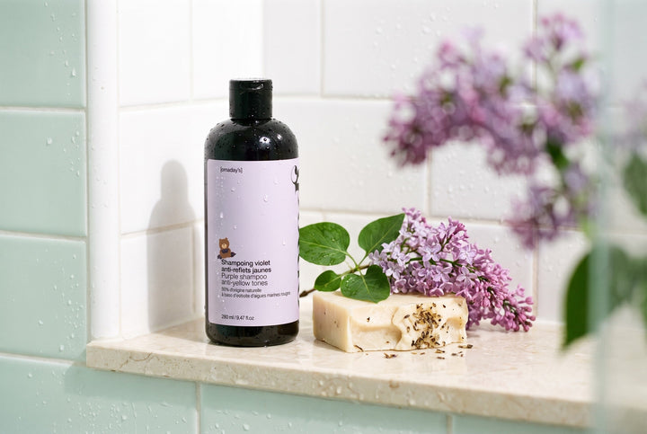 Le shampoing violet OMAD'S dans une scène lifestyle naturelle
