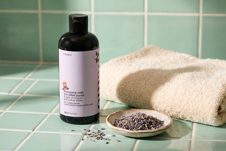 Le shampoing violet OMAD'S dans une scène lifestyle naturelle