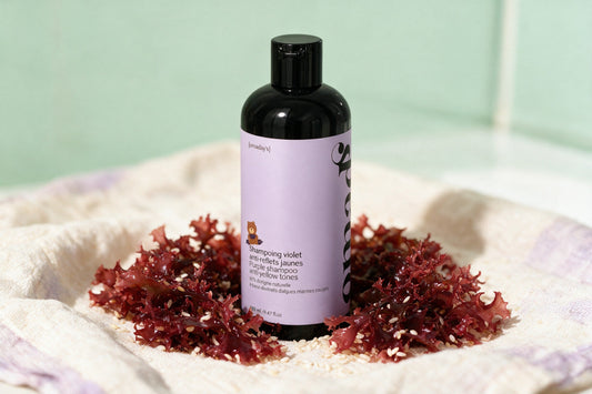 Le shampoing violet OMAD'S entouré de ses ingrédients naturels