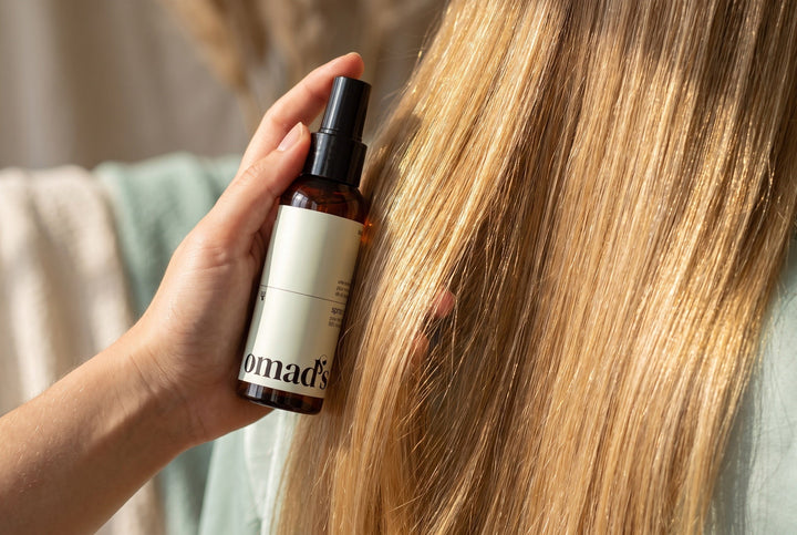 Spray éclaircissant OMAD'S tenu contre des longueurs de cheveux blonds brillants