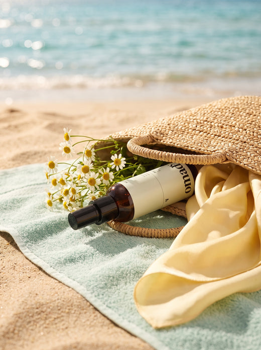 Le spray OMAD'S dans un sac de plage en paille