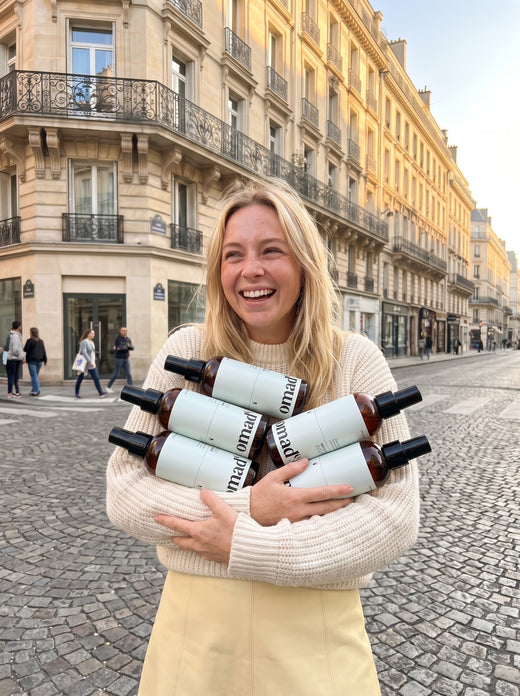 Blonde riant dans une rue de Paris avec cinq sprays eclaircissants OMAD'S geants dans les bras