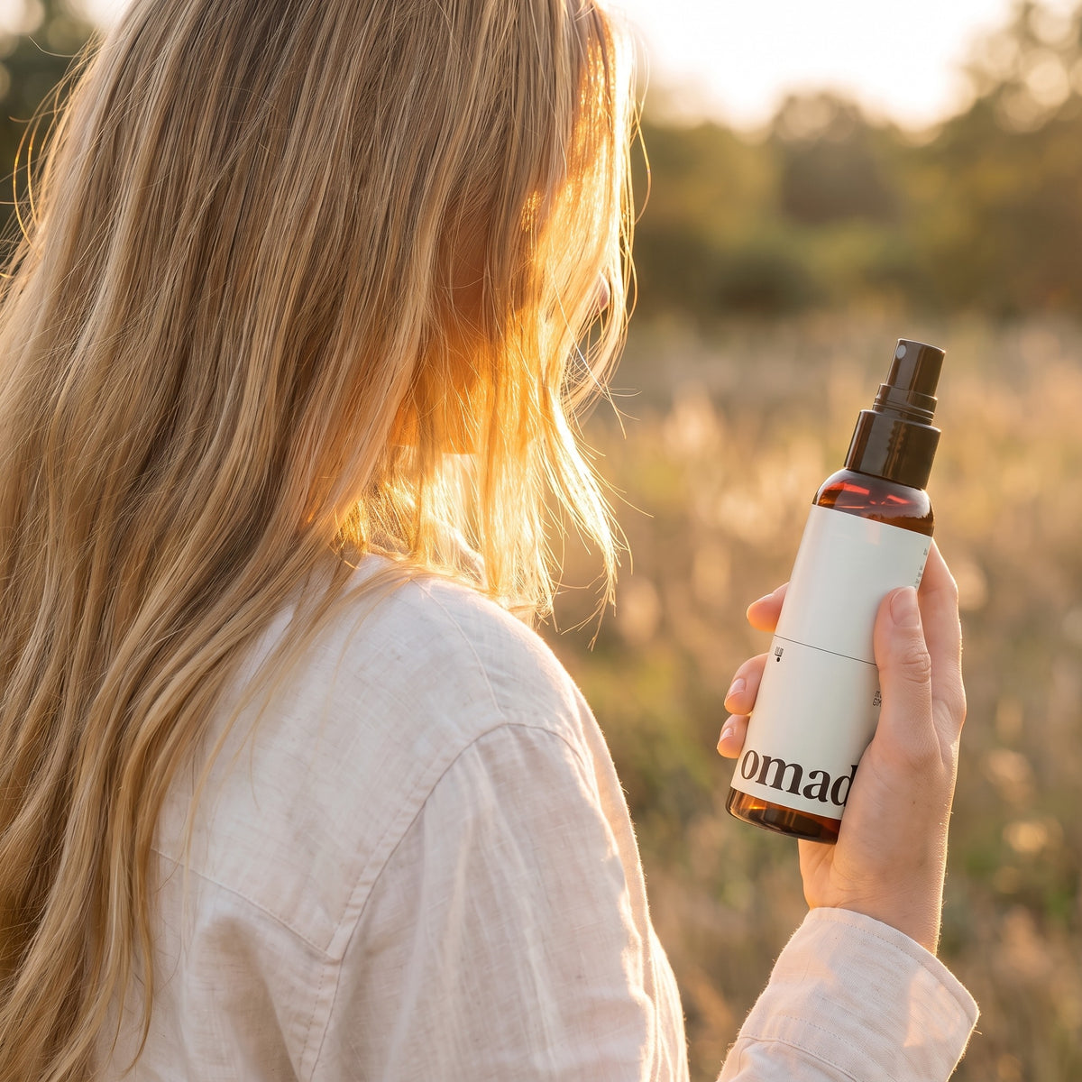 Blonde au soleil couchant avec le spray eclaircissant OMAD'S