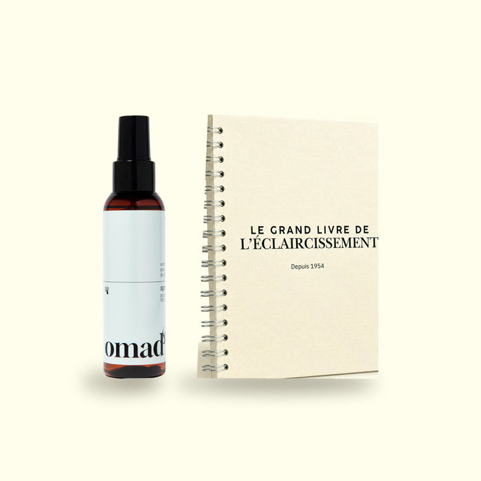 Le spray eclaircissant OMAD'S a cote du Grand Livre de l'eclaircissement